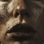 A close-up photo of a long-term smoker's deeply-lined face with dark lips.