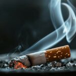 A close-up photograph of a smoldering cigarette in an ashtray, emphasizing filter effectiveness.