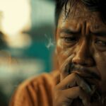 A middle-aged person hesitates to smoke, conveying the consequences of smoking.